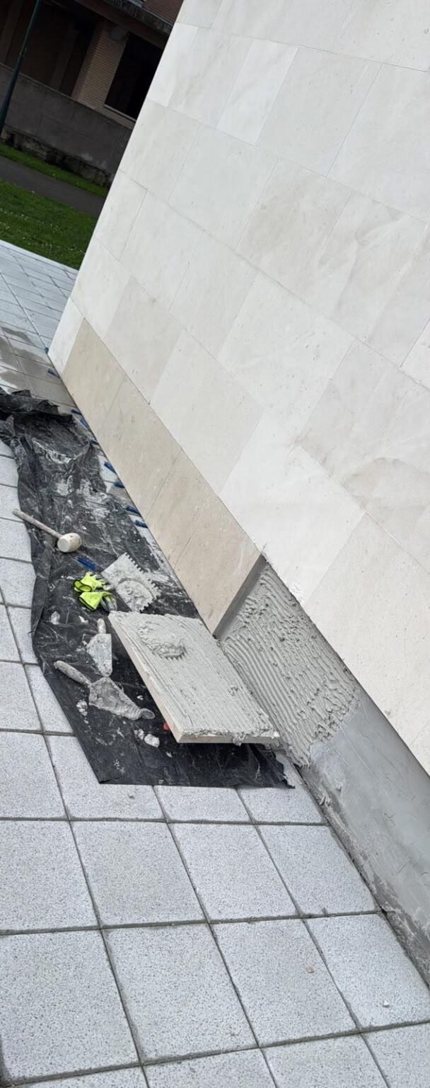 La hilada de mármol repuesta en la base de la fachada