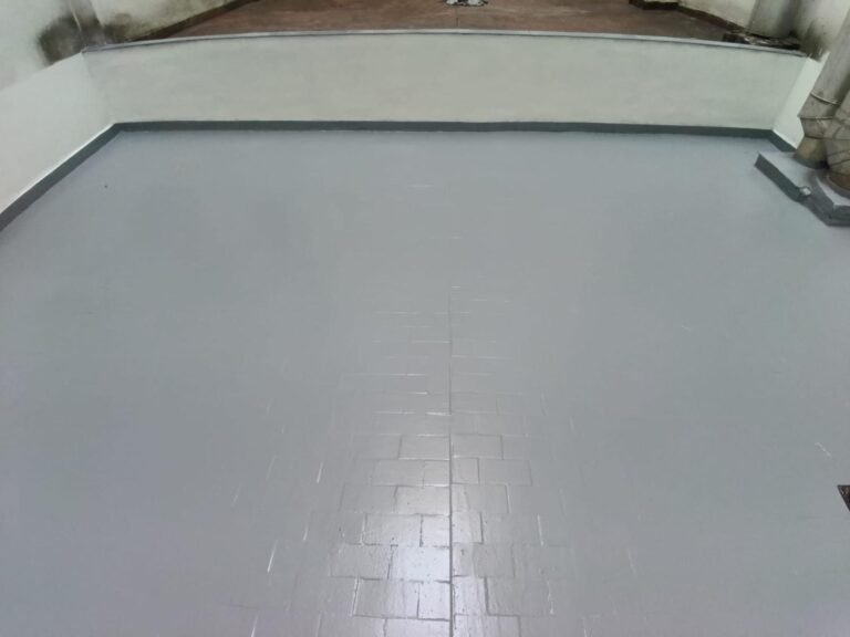 El muro acabado en blanco, con la terraza impermeabilizada en gris