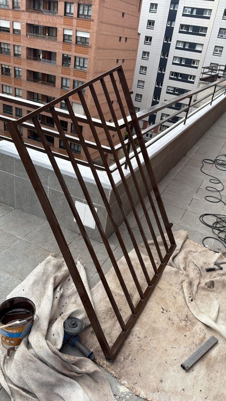 La valla ya pintada, con la brocha y el bote de pintura al lado