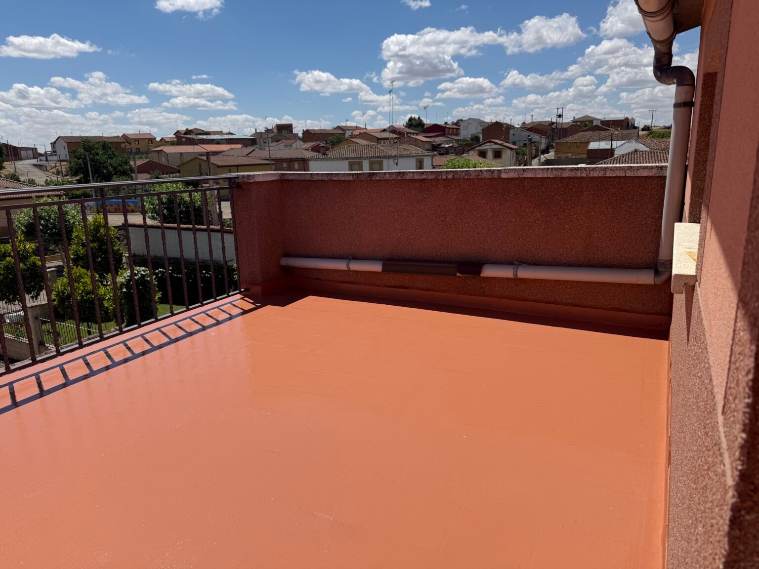 La terraza de León acabada en teja, sobre los tejados del pueblo