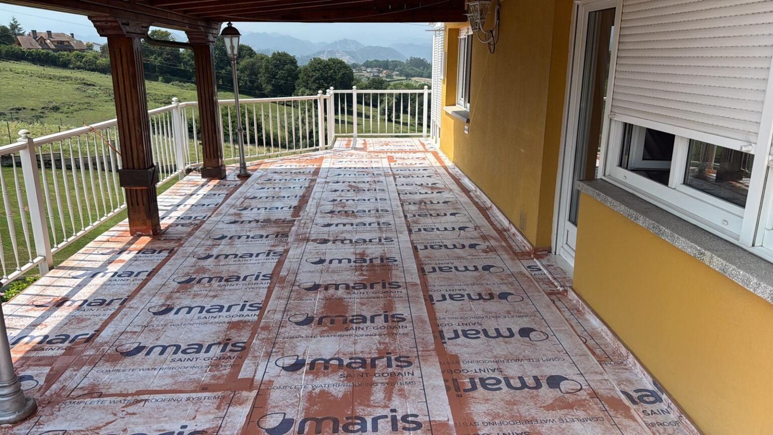 El vellón técnico extendido sobre todo el suelo de la terraza, embebido en Mariseal 250