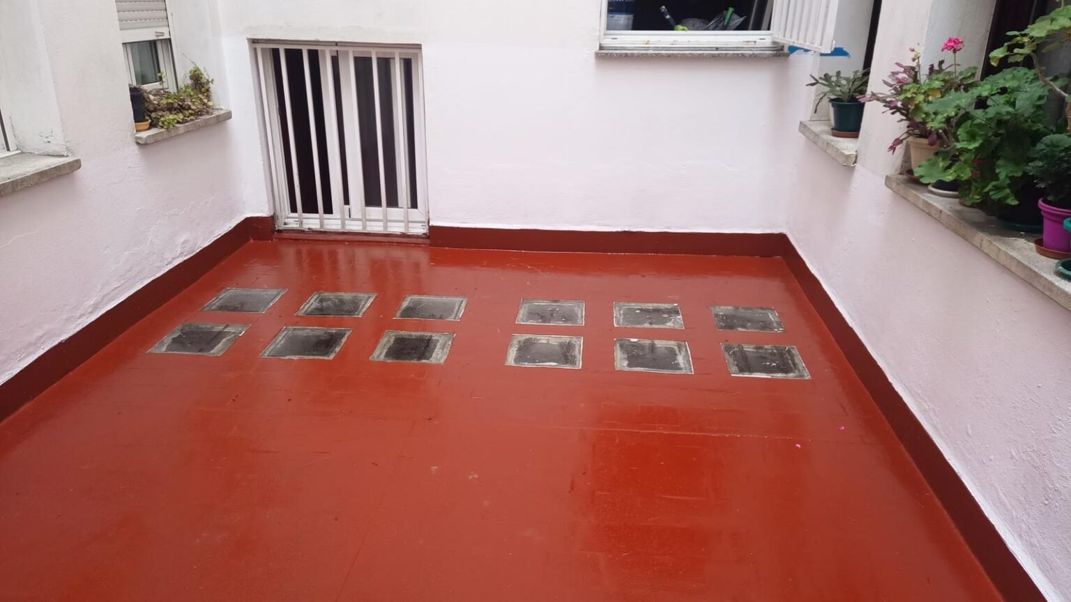 El mismo patio acabado en rojo, con las tapas de registro integradas