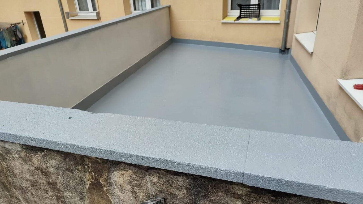 Terraza acabada en gris, con albardilla blanca